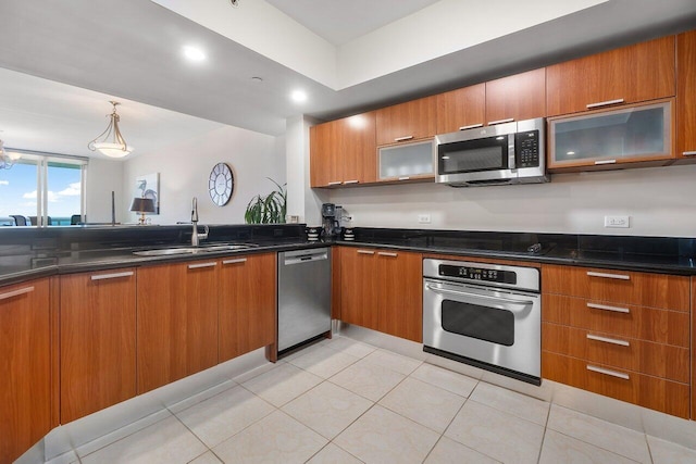 2640 Lake Shore Dr Unit 2409, Riviera Beach, FL 33404 - kitchen featuring stainless steel appliances, a sink, brown cabinetry, and recessed lighting
