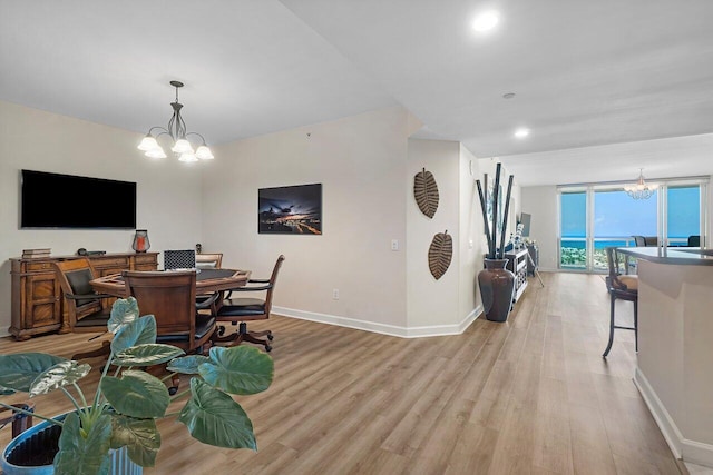2640 Lake Shore Dr Unit 2409, Riviera Beach, FL 33404 - dining space featuring a chandelier, light wood finished floors, baseboards, and a wall of windows
