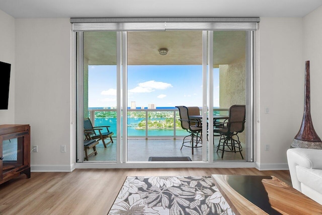 2640 Lake Shore Dr Unit 2409, Riviera Beach, FL 33404 - doorway with wood finished floors, a water view, baseboards, and a wall of windows