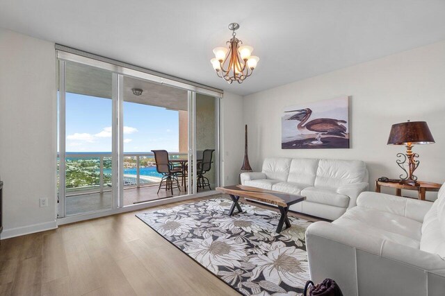 2640 Lake Shore Dr Unit 2409, Riviera Beach, FL 33404 - living area with expansive windows, a chandelier, wood finished floors, and baseboards