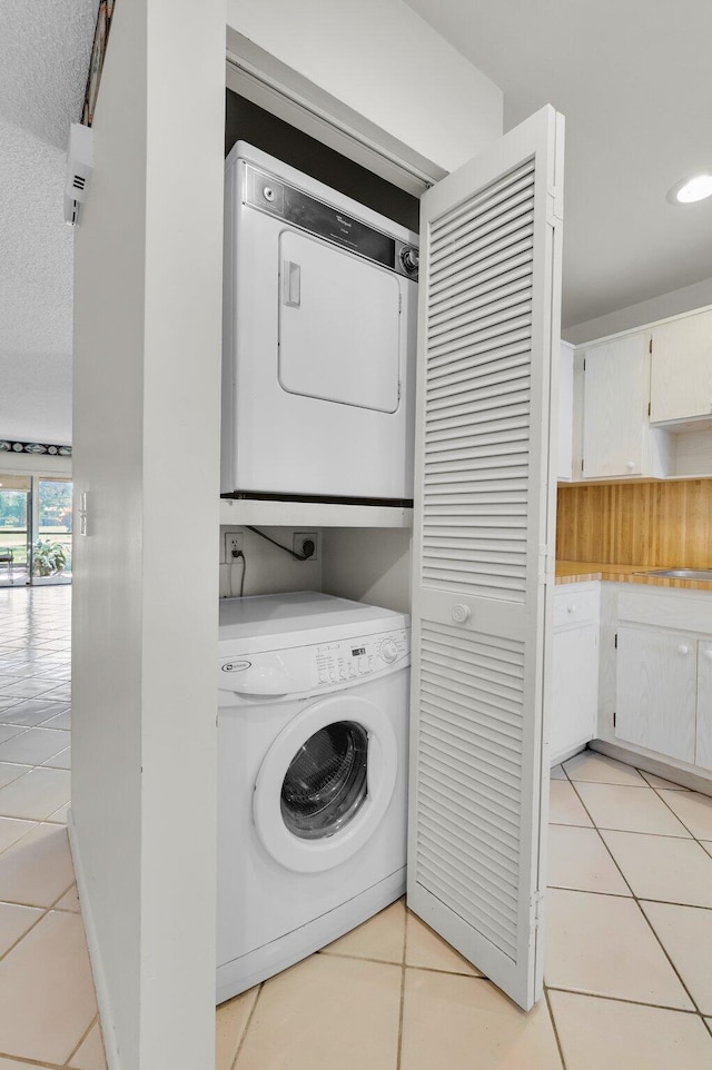 7 Stratford Dr Unit C, Boynton Beach, FL 33436 - laundry room featuring stacked washer and clothes dryer, light tile patterned floors, and recessed lighting