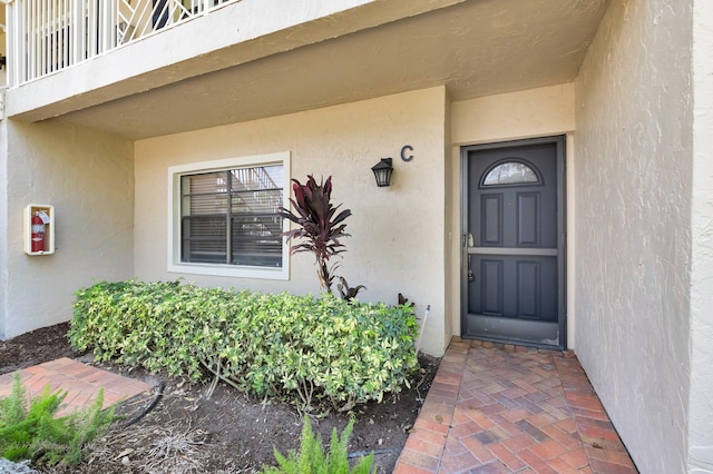 7 Stratford Dr Unit C, Boynton Beach, FL 33436 - doorway to property featuring stucco siding and a balcony