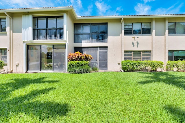 7 Stratford Dr Unit C, Boynton Beach, FL 33436 - back of property with stucco siding and a lawn