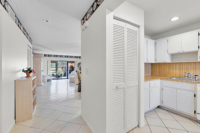 7 Stratford Dr Unit C, Boynton Beach, FL 33436 - hall featuring a sink, light tile patterned floors, recessed lighting, and a textured ceiling