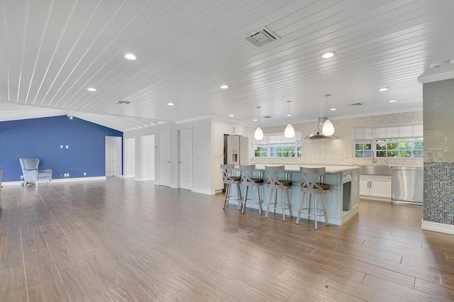 4040 Gem Lake Dr, Glen Ridge, FL 33406 - kitchen featuring appliances with stainless steel finishes, a center island, light countertops, white cabinets, and a kitchen breakfast bar