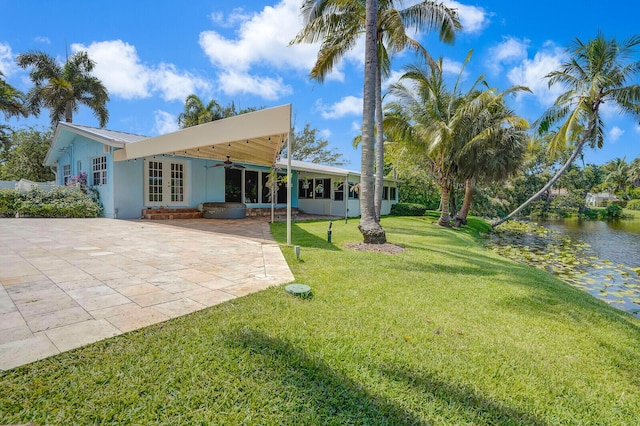 4040 Gem Lake Dr, Glen Ridge, FL 33406 - back of property with french doors, a patio area, a ceiling fan, a lawn, and a water view