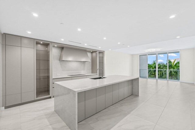 220 SE Mizner Blvd Unit 409, Boca Raton, FL 33432 - kitchen featuring modern cabinets, wall chimney exhaust hood, gray cabinets, a sink, and floor to ceiling windows