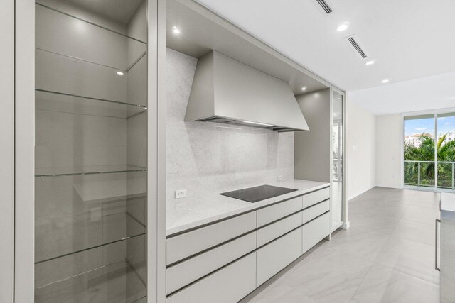 220 SE Mizner Blvd Unit 409, Boca Raton, FL 33432 - kitchen with custom exhaust hood, modern cabinets, black electric cooktop, tasteful backsplash, and recessed lighting