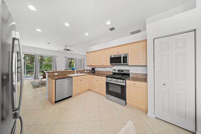 296 NW Toscane Trl, Port Saint Lucie, FL 34986 - kitchen with stainless steel appliances, a sink, a peninsula, light brown cabinets, and recessed lighting