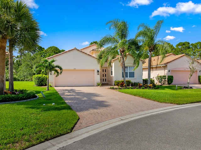 296 NW Toscane Trl, Port Saint Lucie, FL 34986 - mediterranean / spanish house featuring an attached garage, stucco siding, a front lawn, and driveway