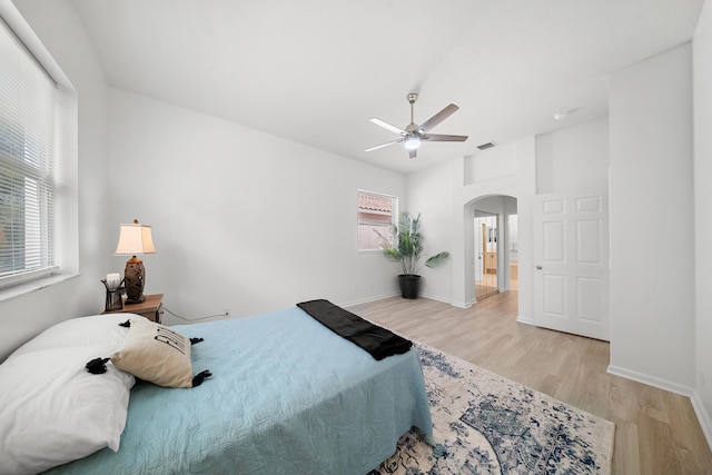 296 NW Toscane Trl, Port Saint Lucie, FL 34986 - bedroom featuring arched walkways, light wood finished floors, baseboards, and a ceiling fan