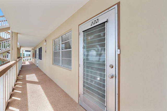 222 Wellington Unit G, West Palm Beach, FL 33417 - doorway to property featuring stucco siding and a balcony