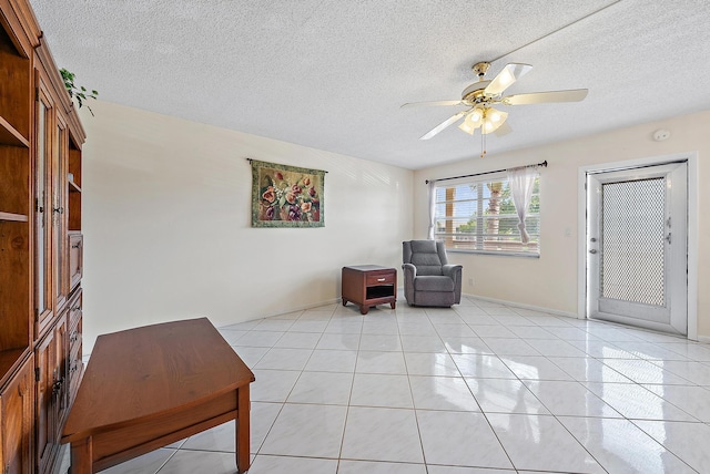222 Wellington Unit G, West Palm Beach, FL 33417 - living area featuring a ceiling fan, a textured ceiling, light tile patterned flooring, and baseboards