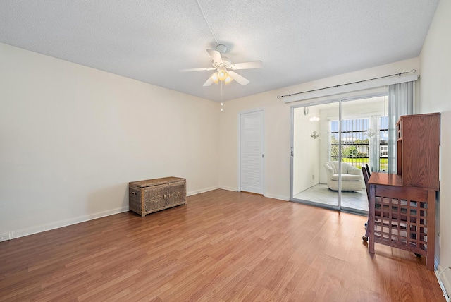 222 Wellington Unit G, West Palm Beach, FL 33417 - empty room featuring a ceiling fan, light wood-type flooring, a textured ceiling, and baseboards