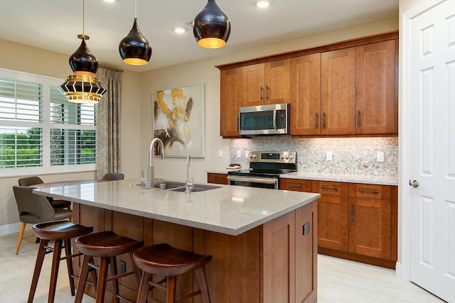 17155 SW Ambrose Way, Port Saint Lucie, FL 34986 - kitchen featuring appliances with stainless steel finishes, a sink, brown cabinets, tasteful backsplash, and light stone countertops