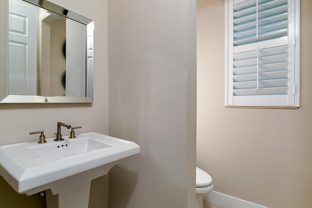 17155 SW Ambrose Way, Port Saint Lucie, FL 34986 - half bathroom featuring a sink, toilet, and baseboards