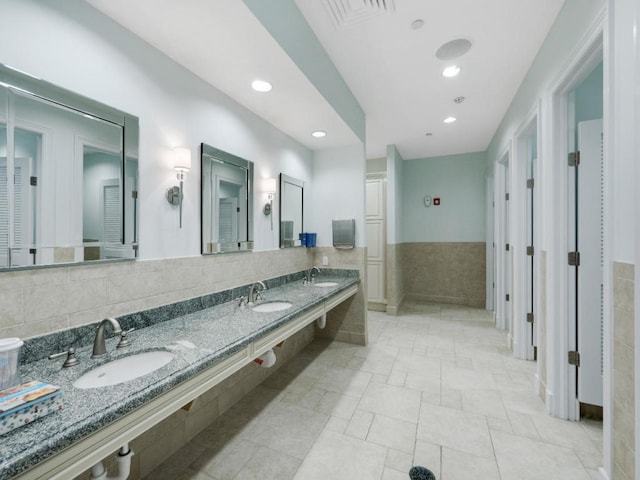 17155 SW Ambrose Way, Port Saint Lucie, FL 34986 - bathroom with tile walls, double vanity, recessed lighting, and a wainscoted wall