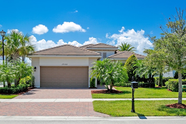 17155 SW Ambrose Way, Port Saint Lucie, FL 34986 - view of front of house with decorative driveway, a garage, a front lawn, and stucco siding