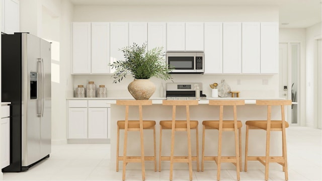 1752 Wandering Willow Way, Loxahatchee, FL 33470 - kitchen with appliances with stainless steel finishes, white cabinetry, light countertops, a breakfast bar, and a kitchen island