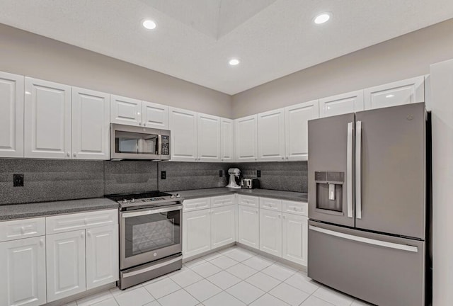 9998 Seacrest Cir Unit C, Boynton Beach, FL 33437 - kitchen featuring appliances with stainless steel finishes, dark countertops, tasteful backsplash, white cabinetry, and recessed lighting