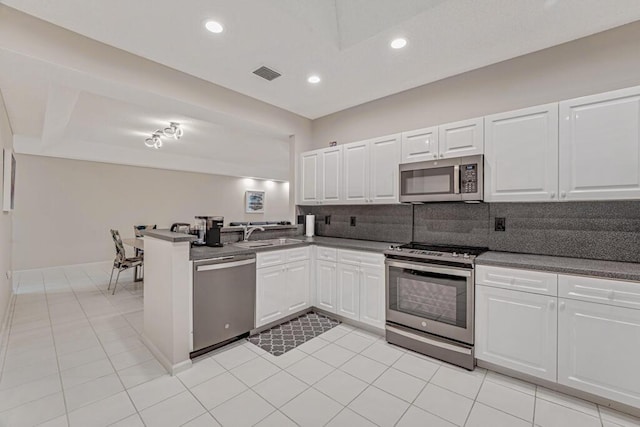 9998 Seacrest Cir Unit C, Boynton Beach, FL 33437 - kitchen featuring stainless steel appliances, a peninsula, white cabinets, dark countertops, and recessed lighting