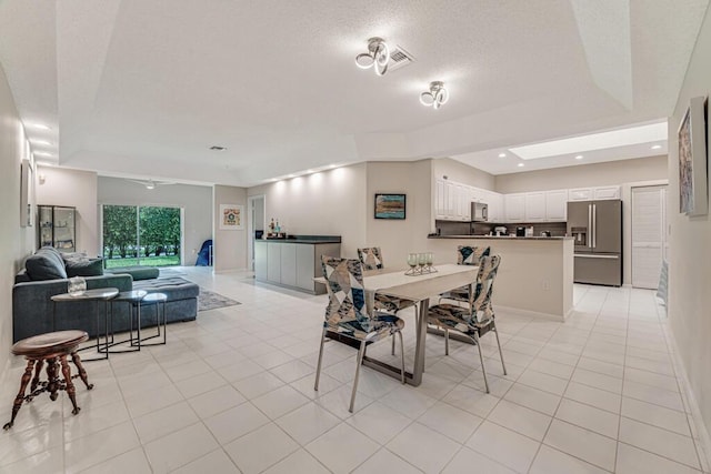 9998 Seacrest Cir Unit C, Boynton Beach, FL 33437 - dining room with light tile patterned flooring, a textured ceiling, and a tray ceiling