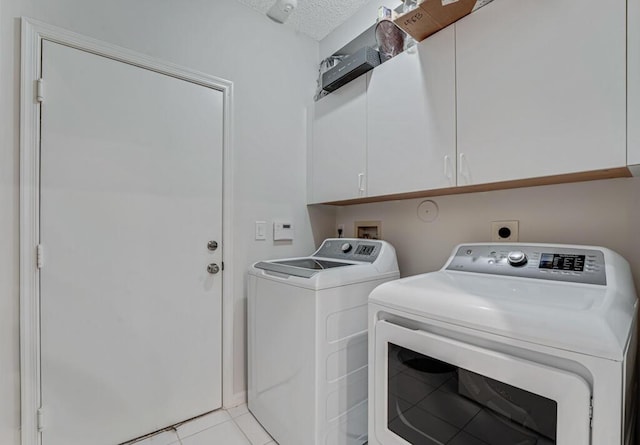 9998 Seacrest Cir Unit C, Boynton Beach, FL 33437 - laundry room featuring cabinet space, washing machine and dryer, a textured ceiling, and light tile patterned flooring