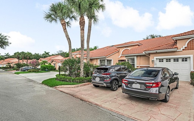 9998 Seacrest Cir Unit C, Boynton Beach, FL 33437 - mediterranean / spanish-style house with a garage, a tiled roof, concrete driveway, and stucco siding