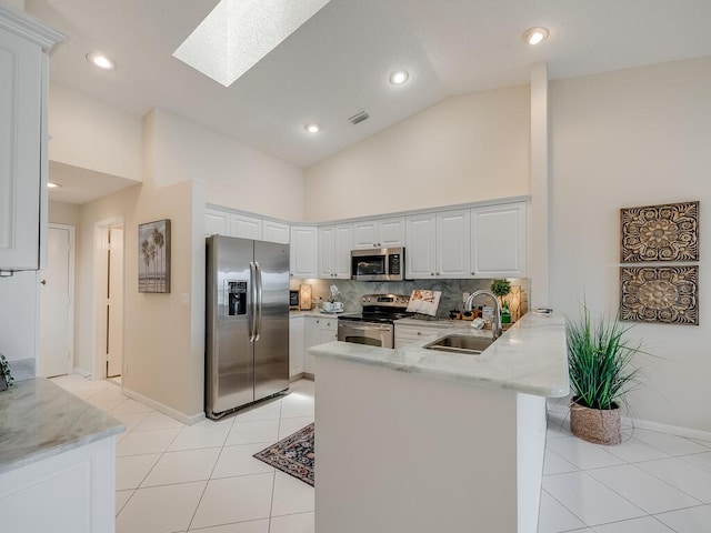 8520 Lake Cypress Rd, Lake Worth, FL 33467 - kitchen with appliances with stainless steel finishes, a sink, a peninsula, high vaulted ceiling, and a skylight