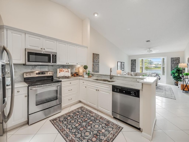 8520 Lake Cypress Rd, Lake Worth, FL 33467 - kitchen featuring appliances with stainless steel finishes, a sink, open floor plan, a peninsula, and decorative backsplash