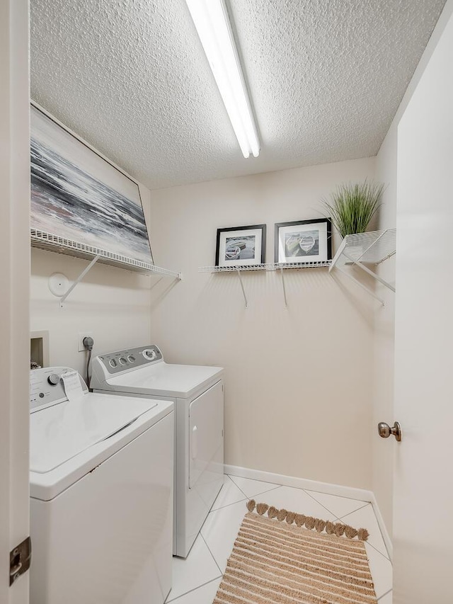 8520 Lake Cypress Rd, Lake Worth, FL 33467 - washroom featuring washing machine and dryer, a textured ceiling, light tile patterned flooring, and baseboards