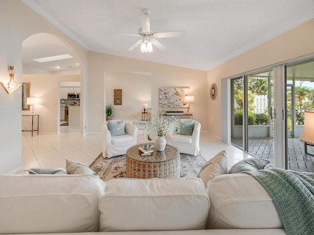 8520 Lake Cypress Rd, Lake Worth, FL 33467 - living room featuring light tile patterned floors, vaulted ceiling, crown molding, arched walkways, and ceiling fan