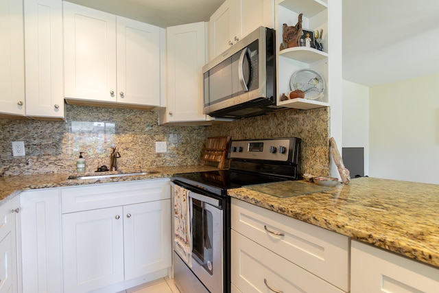 3000 Lake Osborne Dr Unit 103, Lake Worth Beach, FL 33461 - kitchen with appliances with stainless steel finishes, a sink, open shelves, and tasteful backsplash