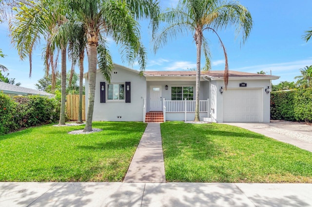 305 Vanderbilt Dr, Lake Worth Beach, FL 33460 - view of front of house with stucco siding, a garage, concrete driveway, and a porch