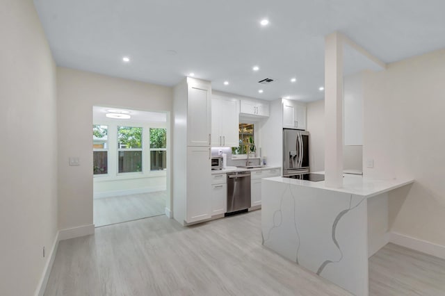 305 Vanderbilt Dr, Lake Worth Beach, FL 33460 - kitchen featuring appliances with stainless steel finishes, light wood-type flooring, white cabinets, baseboards, and recessed lighting