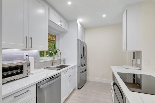 305 Vanderbilt Dr, Lake Worth Beach, FL 33460 - kitchen featuring appliances with stainless steel finishes, baseboards, backsplash, a sink, and light stone countertops