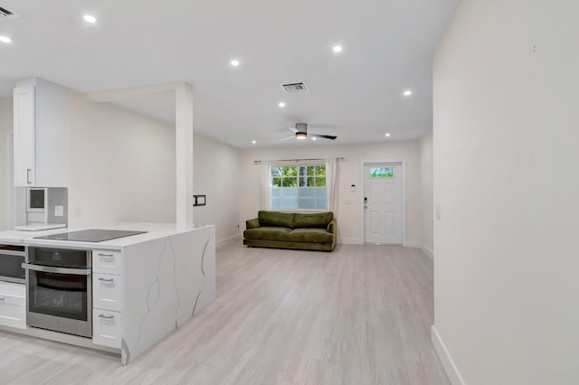 305 Vanderbilt Dr, Lake Worth Beach, FL 33460 - kitchen with stainless steel oven, white cabinets, light countertops, light wood-style floors, and recessed lighting