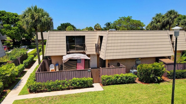 6644 66th Way, West Palm Beach, FL 33409 - back of property featuring brick siding, cooling unit, a tile roof, and mansard roof
