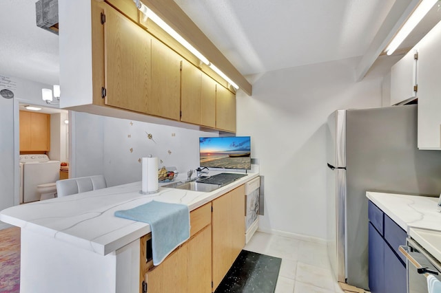 6644 66th Way, West Palm Beach, FL 33409 - kitchen with washer / dryer, a sink, light stone countertops, a peninsula, and freestanding refrigerator