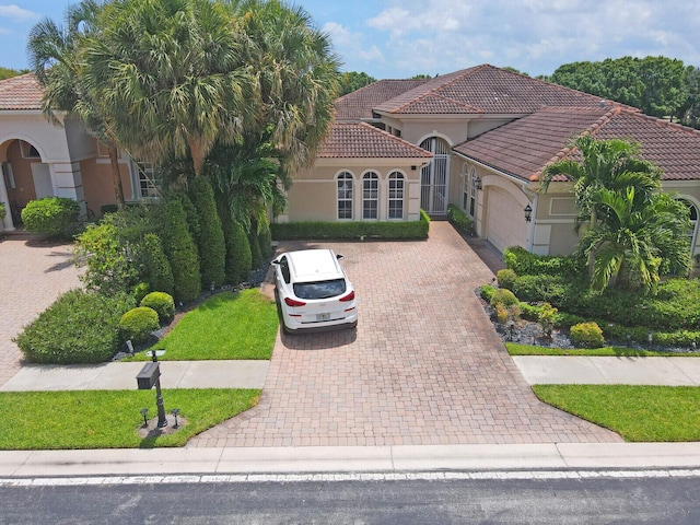6468 Polo Pointe Way, Delray Beach, FL 33484 - mediterranean / spanish-style home with decorative driveway, an attached garage, a tile roof, stucco siding, and a front lawn