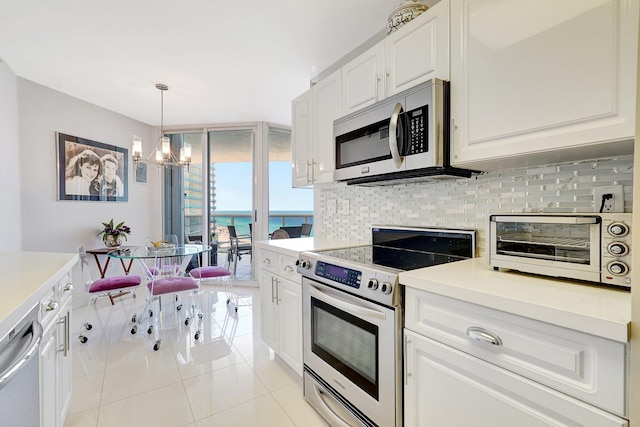 16711 Collins Ave Unit 1906, Sunny Isles Beach, FL 33160 - kitchen with stainless steel appliances, tasteful backsplash, a chandelier, and white cabinetry