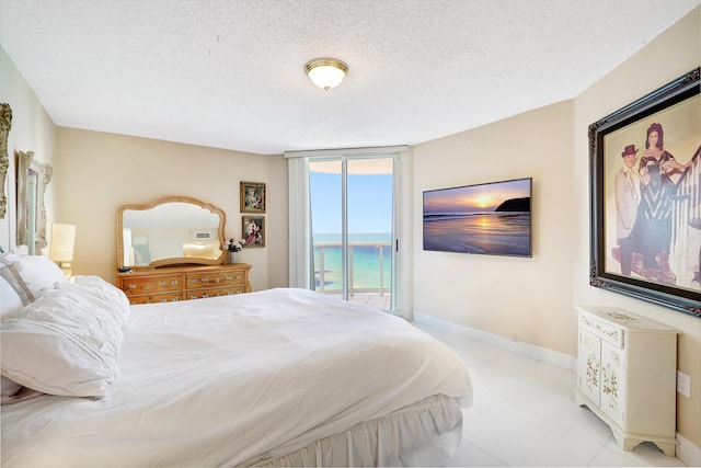 16711 Collins Ave Unit 1906, Sunny Isles Beach, FL 33160 - bedroom featuring access to outside, baseboards, a textured ceiling, and light tile patterned flooring
