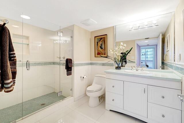 16711 Collins Ave Unit 1906, Sunny Isles Beach, FL 33160 - bathroom with vanity, toilet, a shower stall, and tile patterned flooring