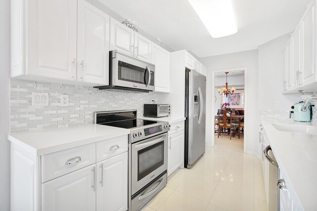 16711 Collins Ave Unit 1906, Sunny Isles Beach, FL 33160 - kitchen featuring appliances with stainless steel finishes, a sink, decorative backsplash, and white cabinetry