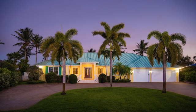 1530 NE Dixie Hwy, Jensen Beach, FL 34957 - ranch-style house featuring curved driveway, a garage, a front lawn, and metal roof