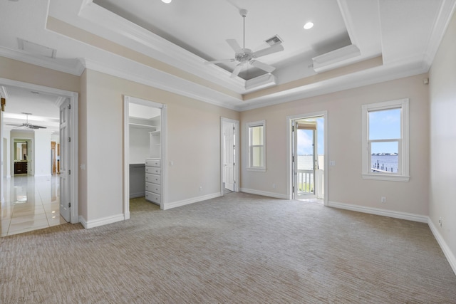 1530 NE Dixie Hwy, Jensen Beach, FL 34957 - unfurnished bedroom featuring a tray ceiling, carpet flooring, ornamental molding, baseboards, and a spacious closet