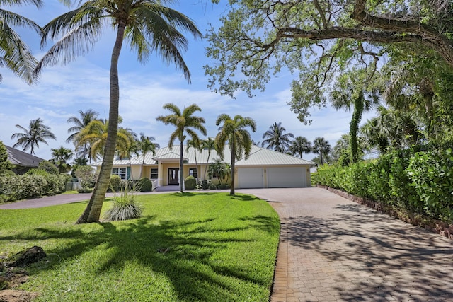 1530 NE Dixie Hwy, Jensen Beach, FL 34957 - ranch-style home featuring a front yard, decorative driveway, a detached garage, and metal roof