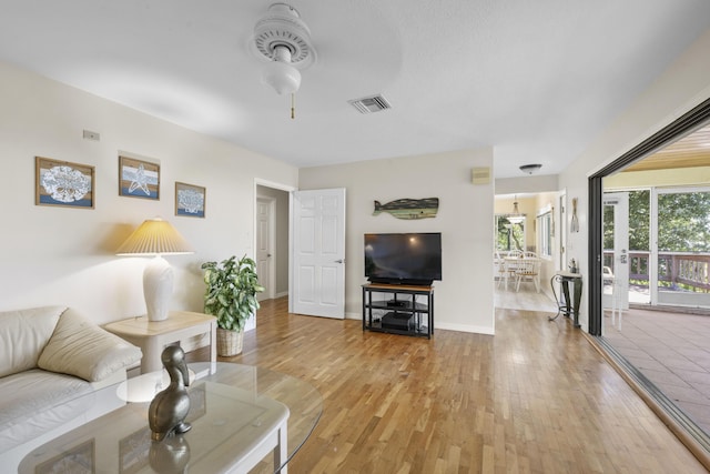 1530 NE Dixie Hwy, Jensen Beach, FL 34957 - living room featuring ceiling fan, light wood-style floors, and baseboards
