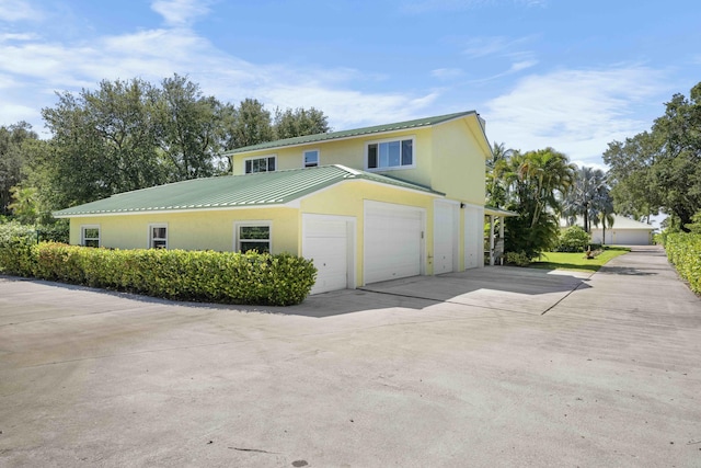 1530 NE Dixie Hwy, Jensen Beach, FL 34957 - traditional-style home featuring stucco siding, concrete driveway, metal roof, an attached garage, and a standing seam roof
