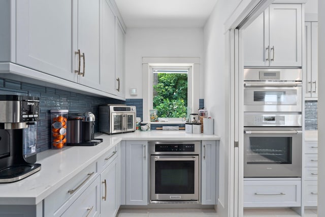 6460 SE Harbor Cir, Stuart, FL 34996 - kitchen featuring decorative backsplash, double oven, and light stone countertops